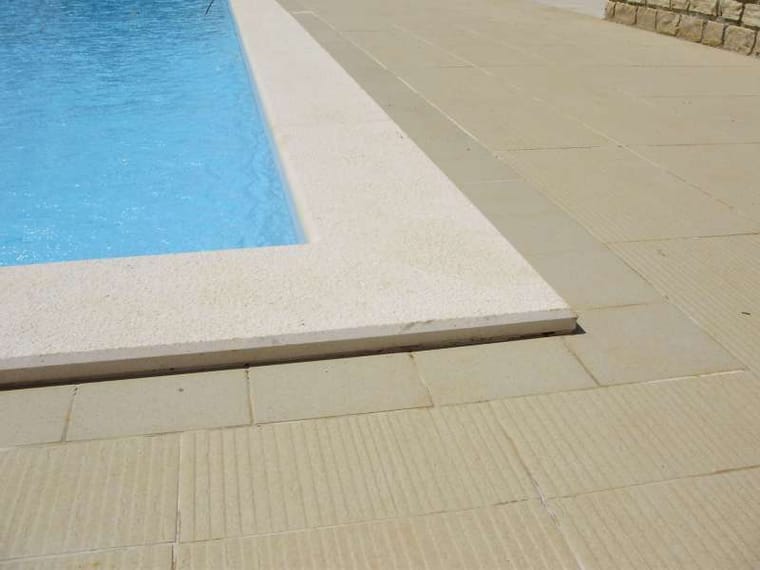 Detalj kuta bazena s bijelim rubnim pločama i žlijebljenim protukliznim opločenjem u bež kamenu, Markvinia Biograd na Moru